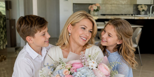 Mother holding pastel pink rose and peony bouquet, hugged by her two children — Floralina Mother's Day flowers Miami